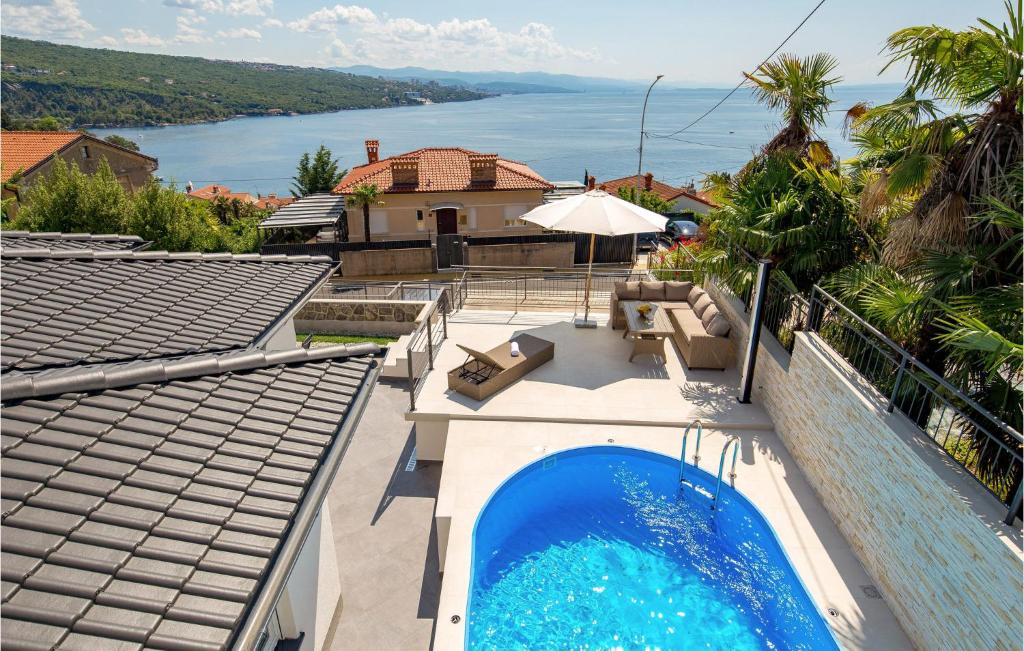 a house with a swimming pool and a view of the water at 2 Bedroom Gorgeous Home In Volosko in Volosko