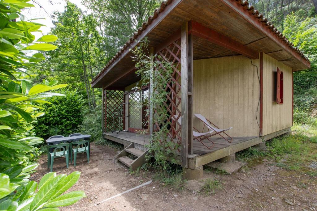 a gazebo with a bench and a table at Bungalow Moulin Du Gournier in Malbosc