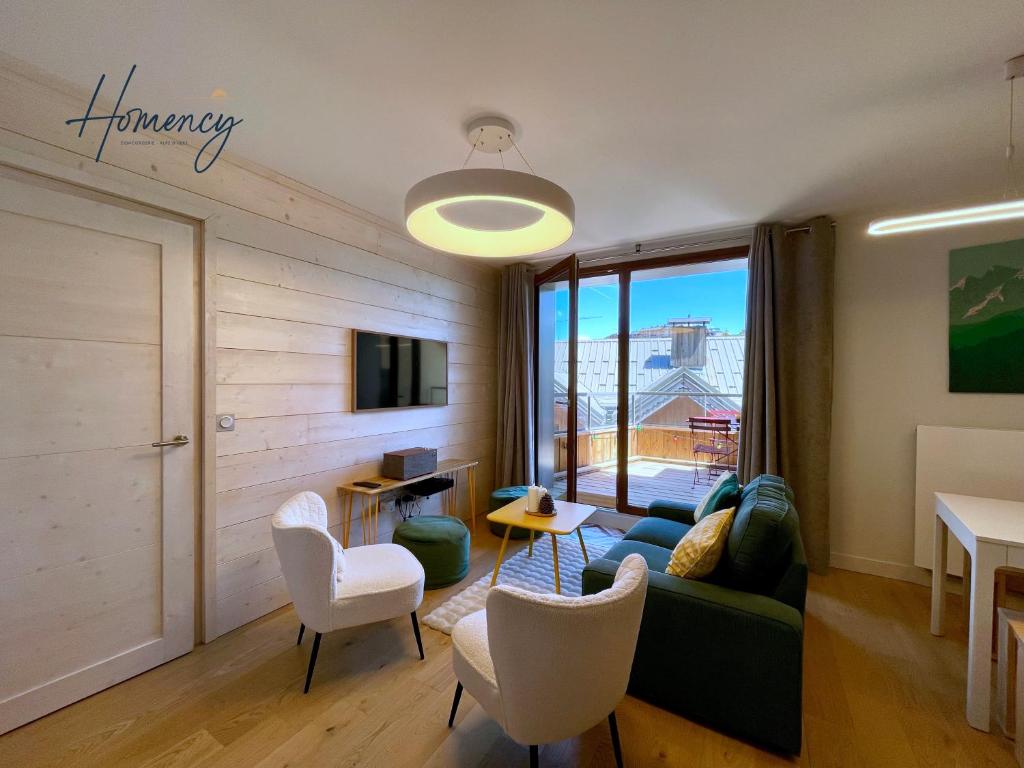 un salon avec un canapé, des chaises et une télévision dans l'établissement Homency - Résidence Fermes de l'Alpe A302, à L'Alpe-d'Huez