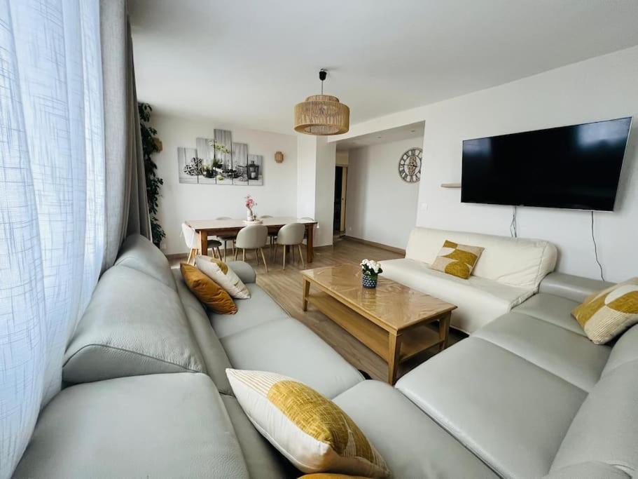 un salon avec un canapé et une table dans l'établissement Paris - Appartement confortable proche Canal Ourcq, à Paris