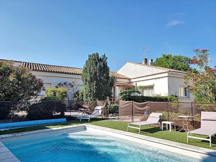une piscine devant une maison dans l'établissement Grande villa entièrement rénovée avec piscine, à Pinet
