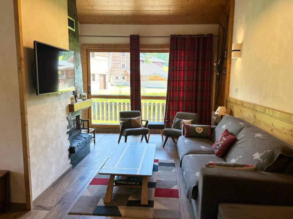 un salon avec un canapé et une table dans l'établissement Les Gets - Appartement rénové 12 pers, 4 ch, parking, WIFI, proche piste - FR-1-623-7, aux Gets