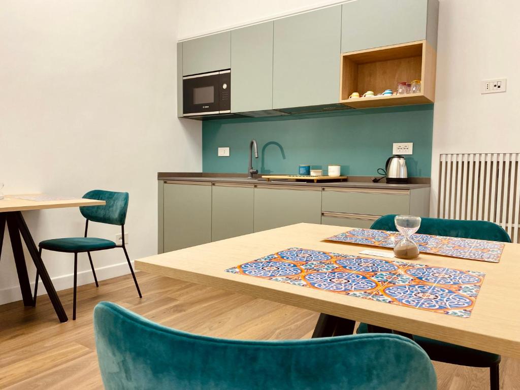 a kitchen with a wooden table and green chairs at Dimora Donna Maria Relais in Cava deʼ Tirreni