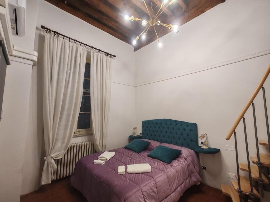 ein Schlafzimmer mit einem lila Bett und einem Fenster in der Unterkunft Corte Aranci Deluxe Apartment in Historic Center Of Lucca in Lucca