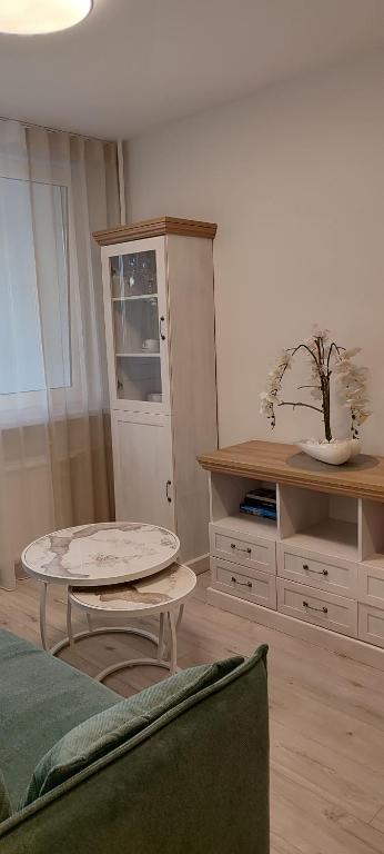 a living room with a coffee table and a cabinet at Cozy Kaunas apartment in Kaunas