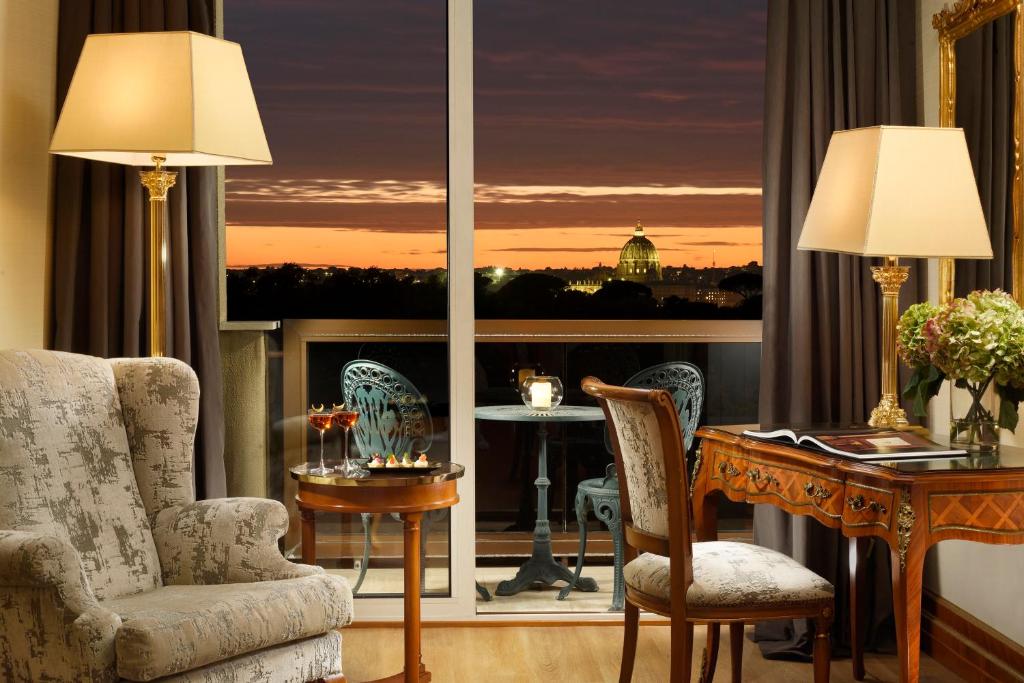 a living room with a table and chairs and a large window at Parco dei Principi Grand Hotel & SPA Roma - Preferred Hotels & Resorts in Rome