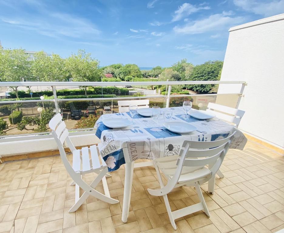 une table blanche et des chaises sur un balcon dans l'établissement Pacific 1-Studio cabine, vue mer, parking, à La Grande Motte
