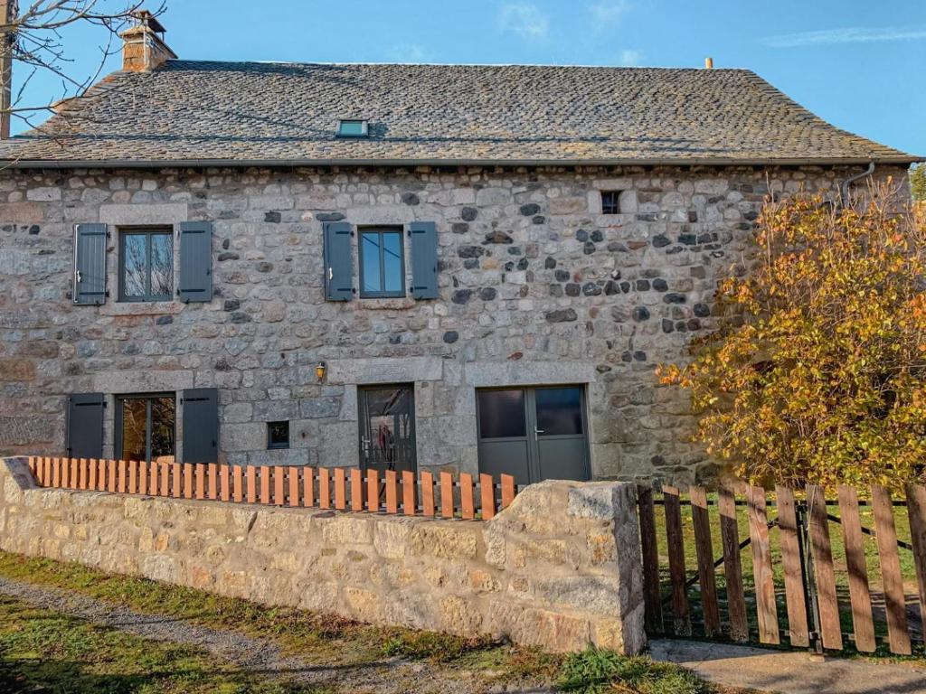 an old stone house with a wooden fence at Gîte Gîtes de France 6/7 personnes à Baboyères in Nasbinals