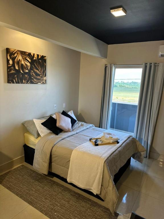 a bedroom with a bed and a large window at Riacho Hotel in Brasília