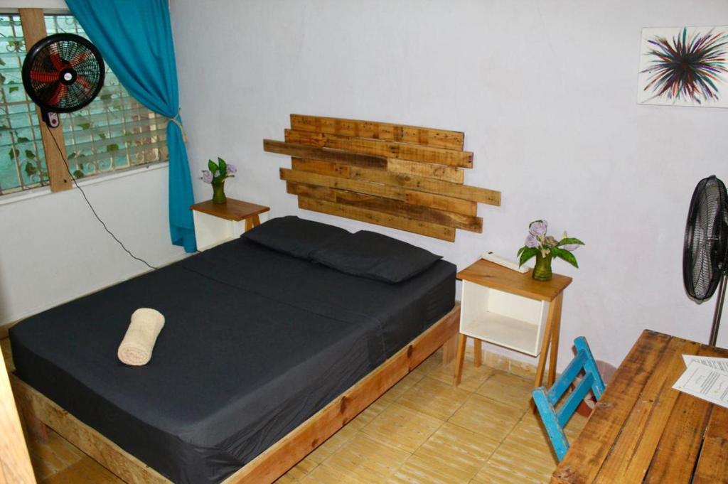 Un pequeño dormitorio con una cama y una mesa. en Casa Samay, en Cozumel