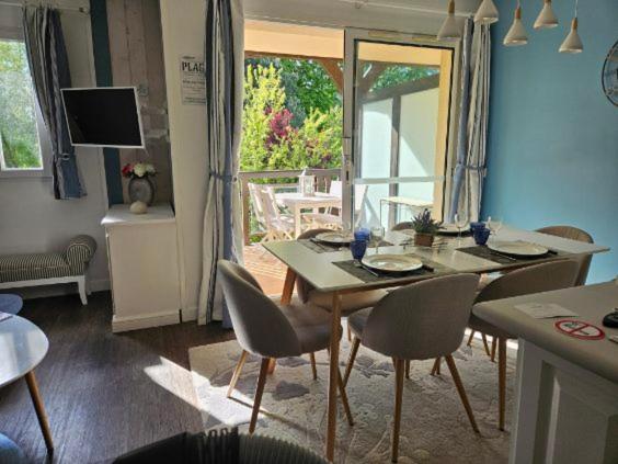 une table à manger et des chaises dans un salon dans l'établissement O Fil de l'eau Deauville piscine chauffée, à Deauville