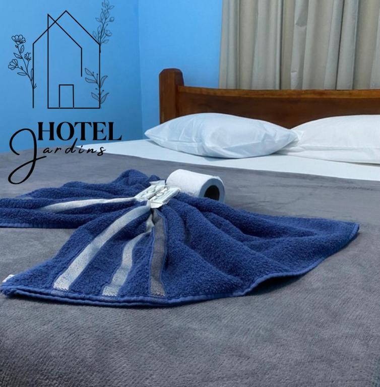 a blue blanket is sitting on a bed at Hotel Jardins in Porto Velho