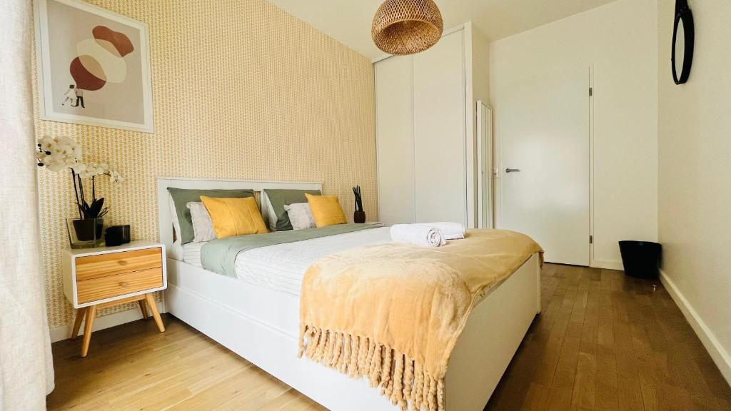 une chambre avec un grand lit et un parquet dans l'établissement Riviera Suite - Spacieux T3 - 5 min du métro- Paris centre à 10min, à Asnières-sur-Seine