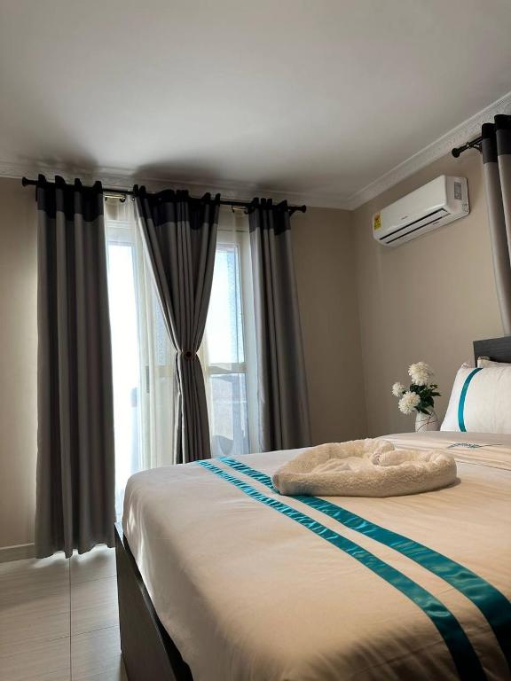 a bedroom with a large bed with a window at Mansah Plus Hotel and Apartments in Accra