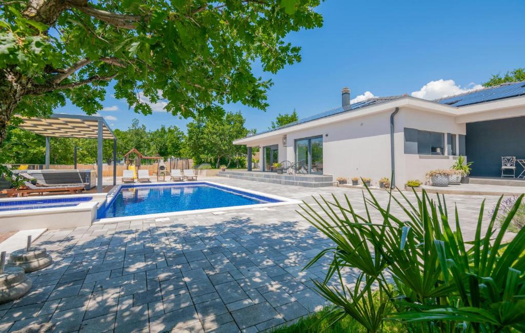 een achtertuin met een zwembad en een huis bij Gorgeous Home In Glavina Gornja in Gornja Glavina