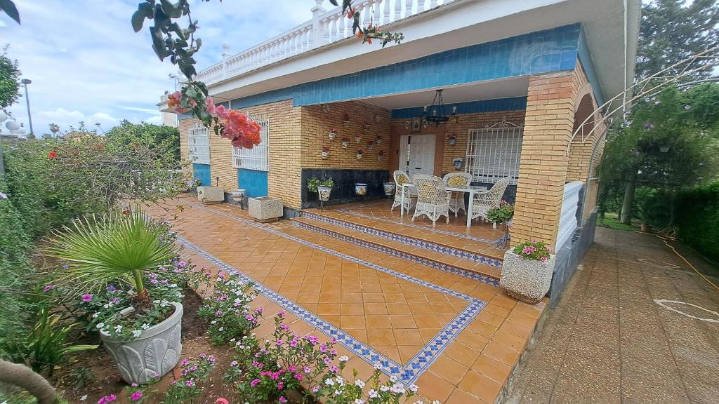 dom z patio ze stołem i krzesłami w obiekcie Sevilla, Casa Rural Villa Amalia w mieście Alcalá de Guadaira