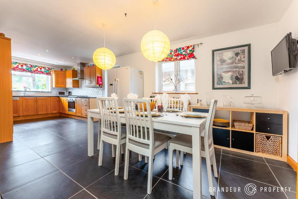 a kitchen and dining room with a white table and chairs at Bracken Bliss by Grandeur Property in Ferndown