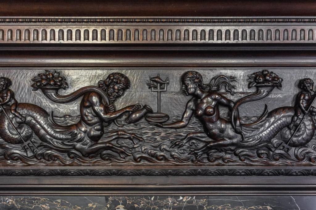 a metal relief of a mermaid and a snake at The Benjamin House in Rīga