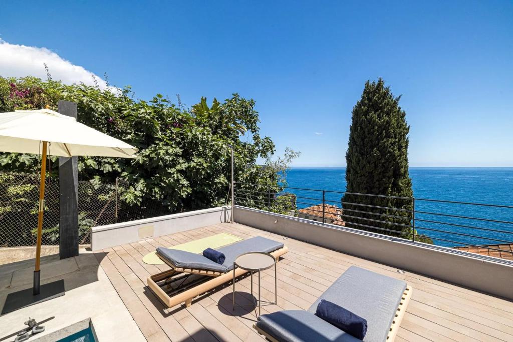 balcone con sedie, ombrellone e oceano di Villa Neuve, proche Monaco a Roquebrune-Cap-Martin