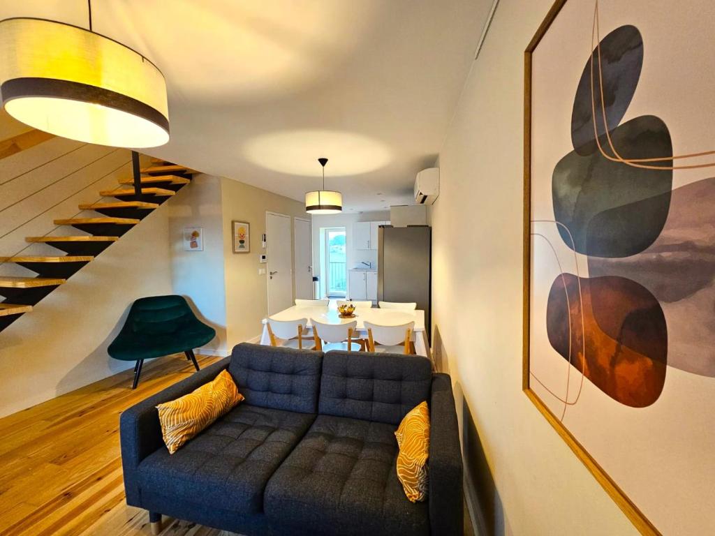 un salon avec un canapé bleu et une table dans l'établissement Sous les toits dans les nuages, à Dax