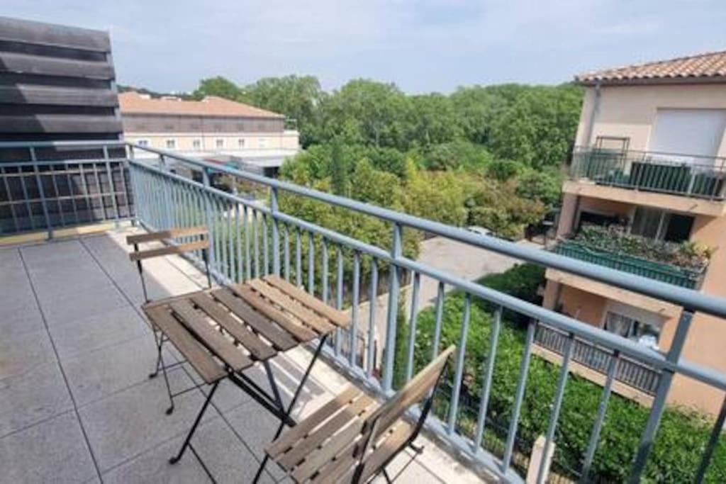 un balcon avec deux chaises et une table sur un immeuble dans l'établissement Le Pompéi, à Juvignac