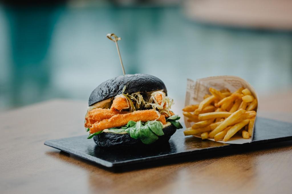 a sandwich and french fries on a black plate at Vale d'El Rei Hotel & Villas in Carvoeiro