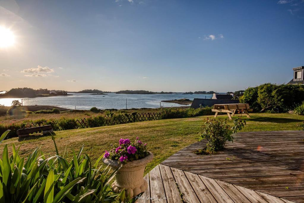 une passerelle en bois avec des fleurs dans un pot dessus dans l'établissement Les Bambous de Bugueles, à Penvénan