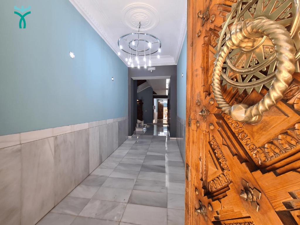 a hallway with a wooden door with a rope on it at Dos Torres Retiro Urbano en Alfonso I in Zaragoza