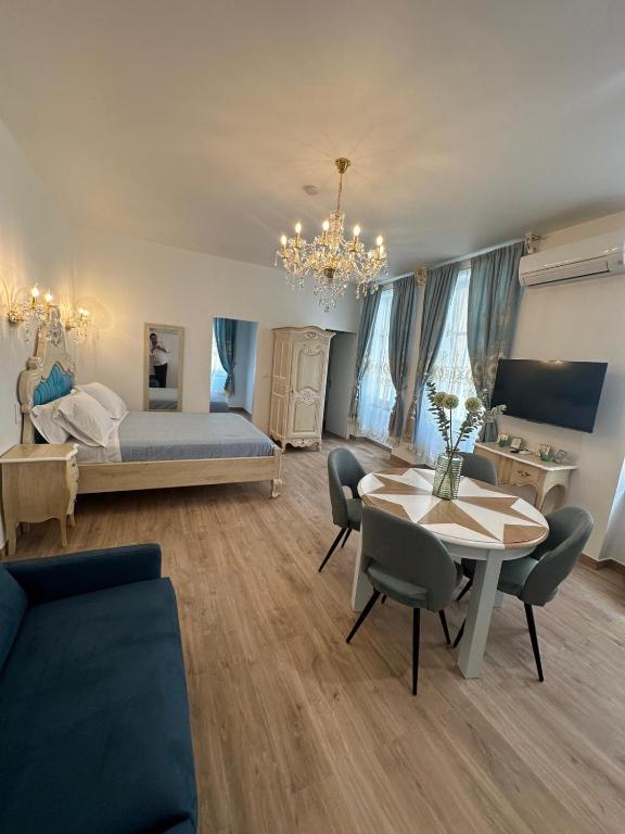 un salon avec un lit, une table et des chaises dans l'établissement Appartement du Cloitre 1er, à Narbonne