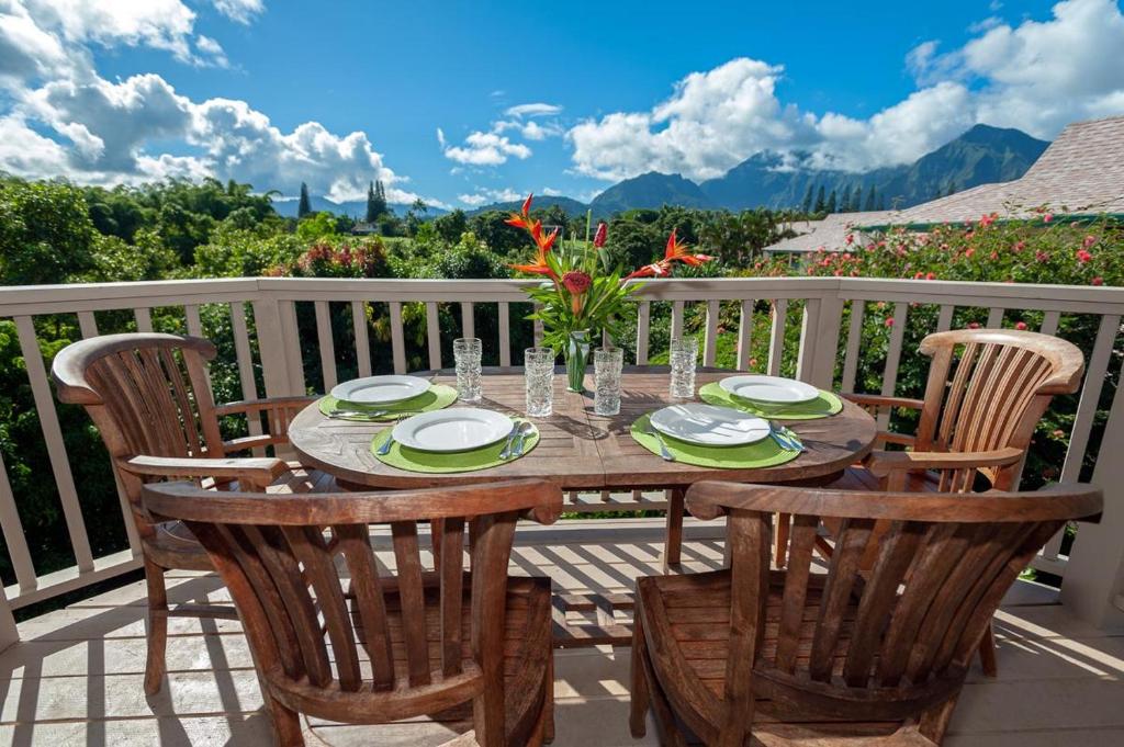 a wooden table and chairs on a balcony with a view at Hanalei Bay Villa 26 in Princeville