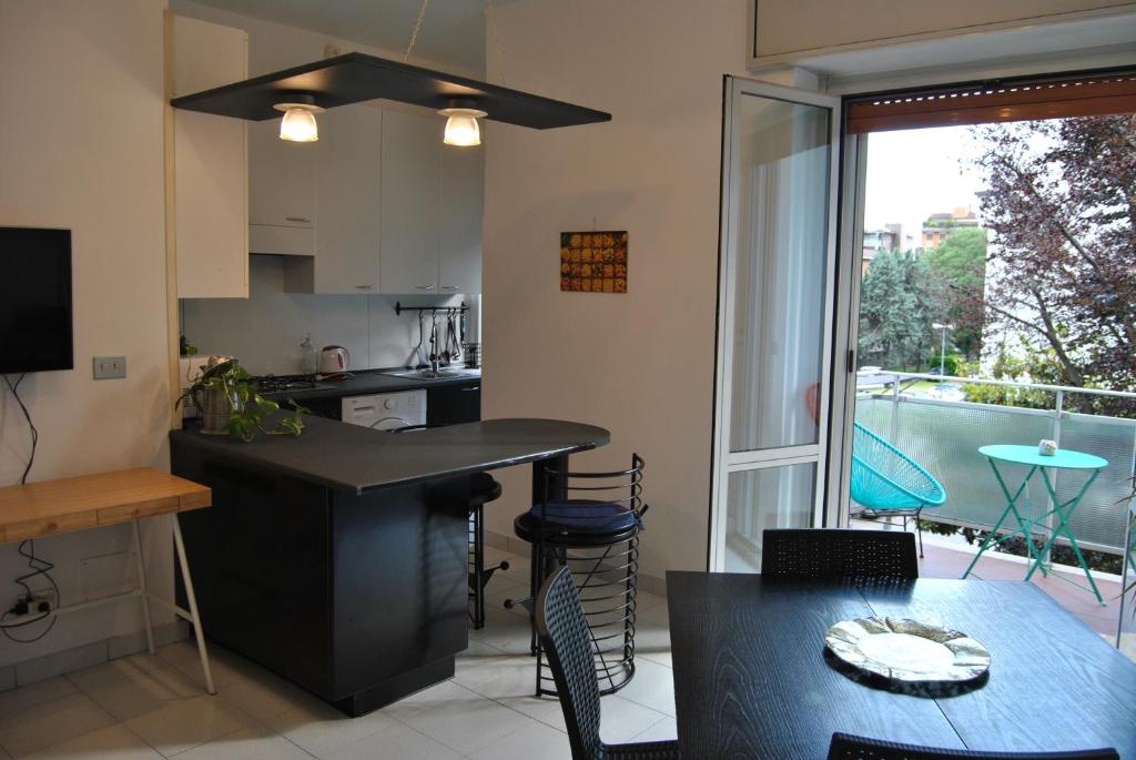 a kitchen and dining room with a table and a window at Portello Flat with Balcony in Milan