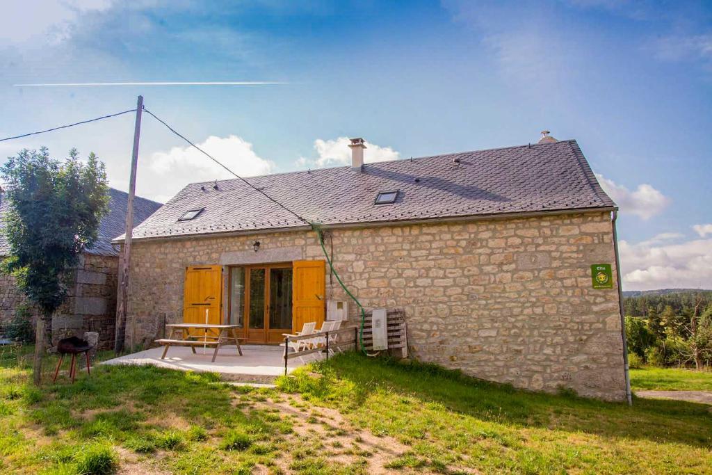 a small stone house with a table and a bench at Gîte Gîte La Grange de Chabanettes 3/6 personnes in Termes