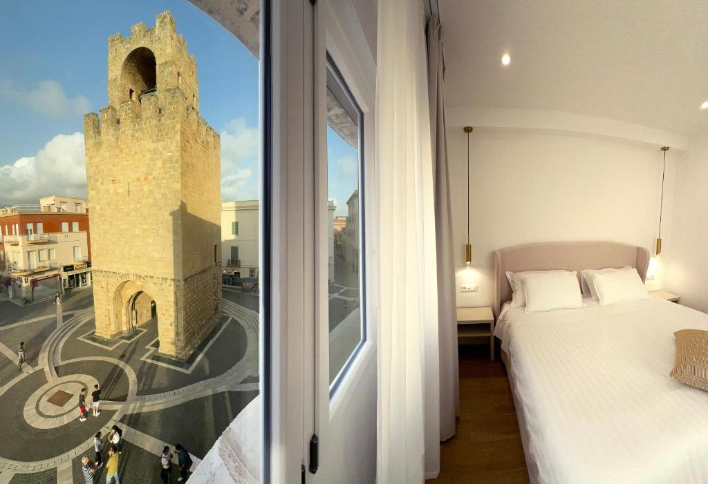 a bedroom with a bed and a window with a tower at Feel Boutique Rooms in Oristano