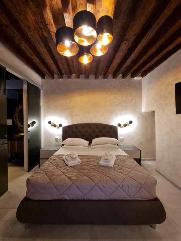 a bedroom with a large bed with two towels on it at San Marco 3097 - LuxuryJacuzzi in Venice