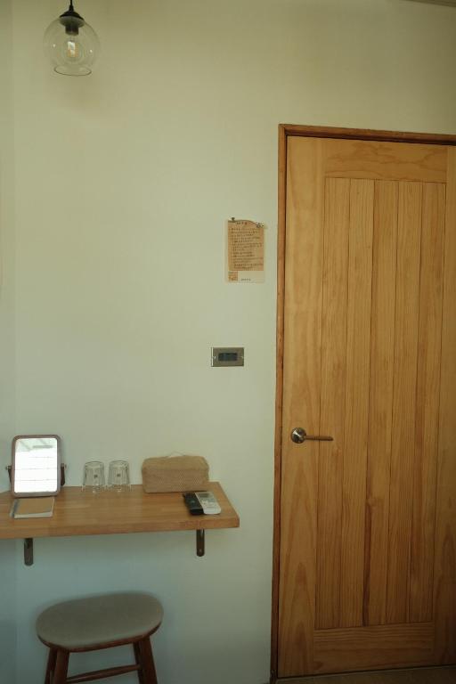 a room with a wooden door and a table and a stool at Maru in Tainan