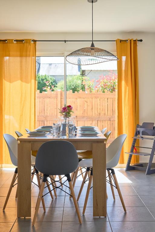 une table à manger avec des chaises et un éclairage dans l'établissement Charmante maison moderne à deux pas de la mer !, à Lancieux