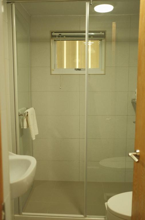 a bathroom with a shower and a toilet and a sink at Maru in Tainan
