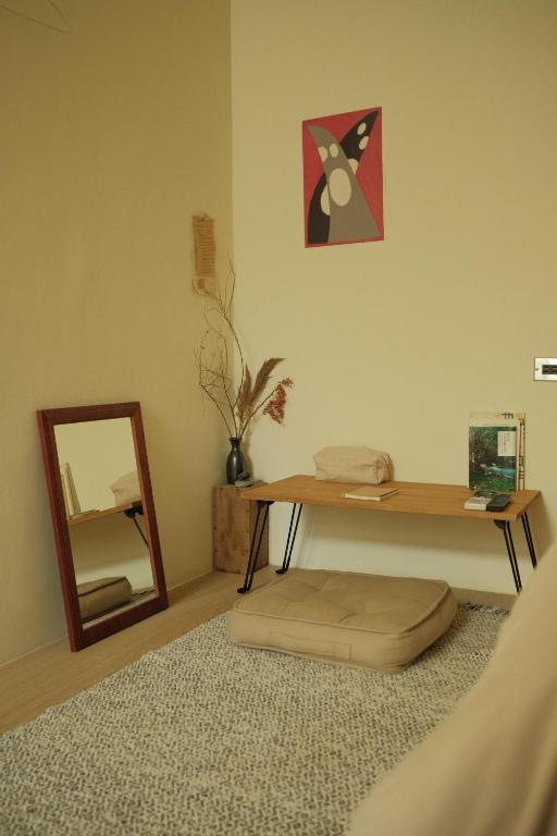 a room with a table and a mirror and a rug at Maru in Tainan