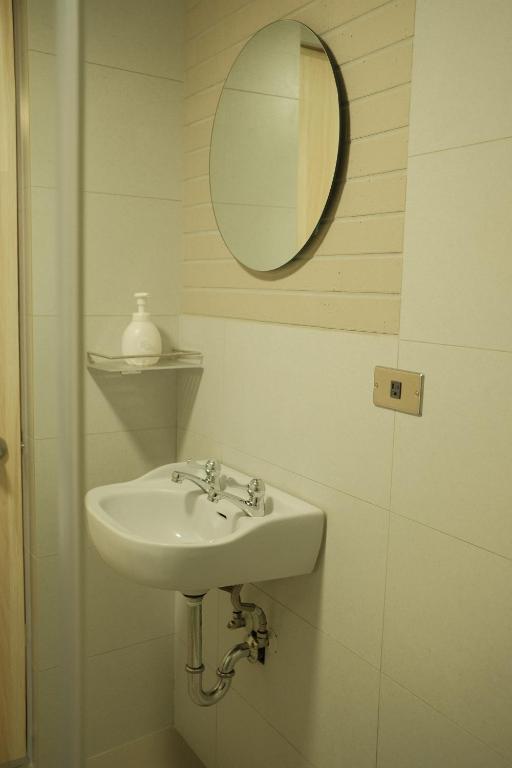 a bathroom with a sink and a mirror at Maru in Tainan