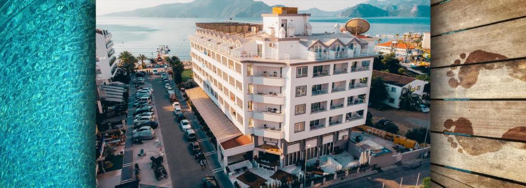 een hoog wit gebouw naast het water bij Mert Seaside Hotel in Marmaris