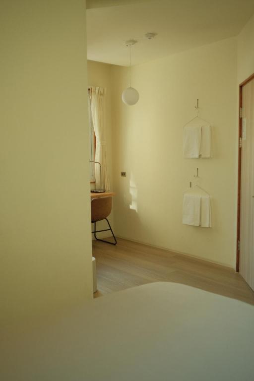 a white room with a table and a mirror at Maru in Tainan