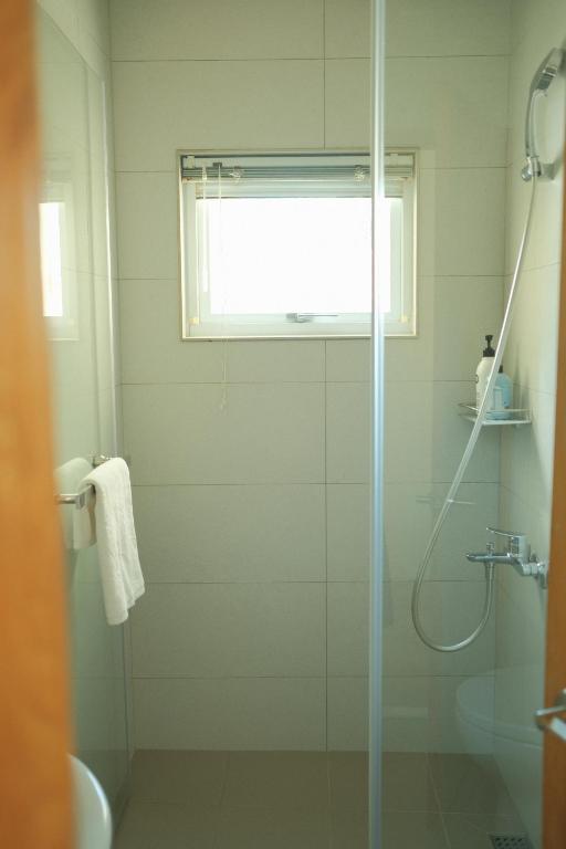 a bathroom with a shower with a glass door at Maru in Tainan