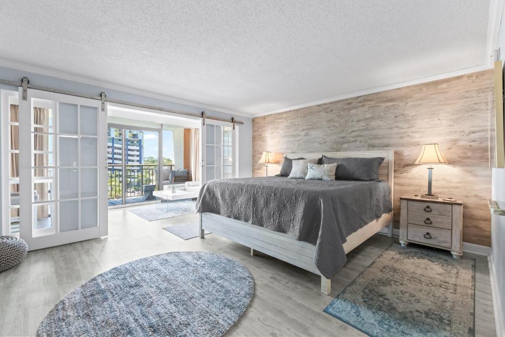 een slaapkamer met een bed en een houten wand bij New Oceanview Suite - Caravelle 504 in Myrtle Beach