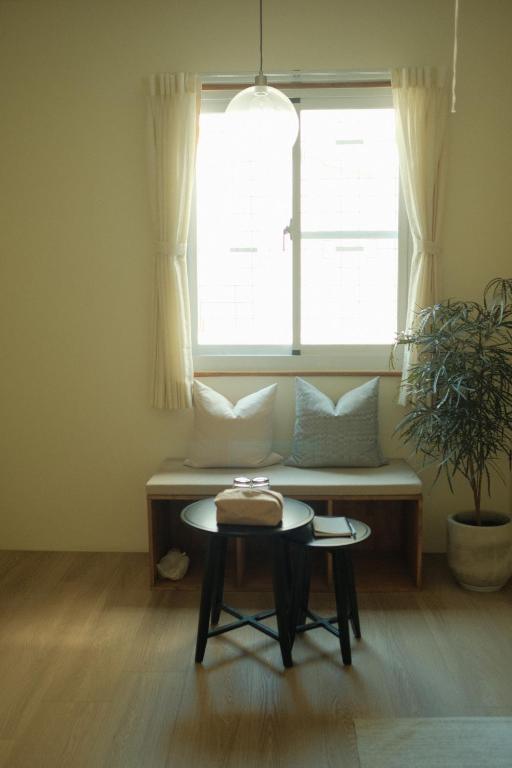 a living room with a bench and a window at Maru in Tainan