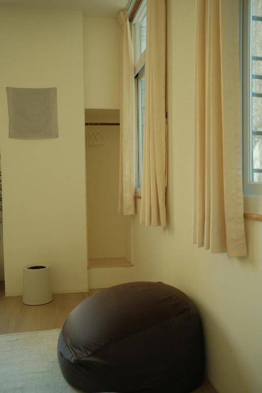 a black ottoman in a room with a window at Maru in Tainan