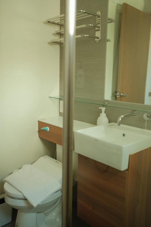 a bathroom with a sink and a toilet and a mirror at Maru in Tainan