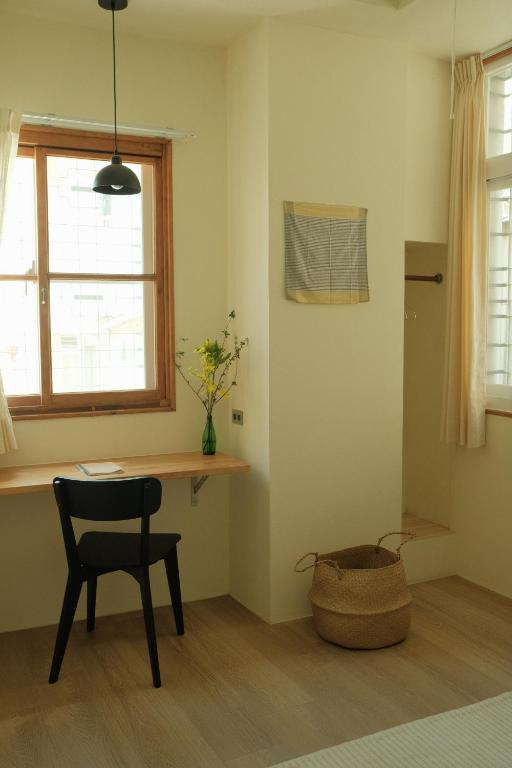 a room with a table and a chair and a window at Maru in Tainan