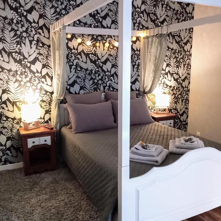 - une chambre avec un lit et 2 tables avec des serviettes dans l'établissement Chambre Nounours et Paillette, à Braye-sous-Faye