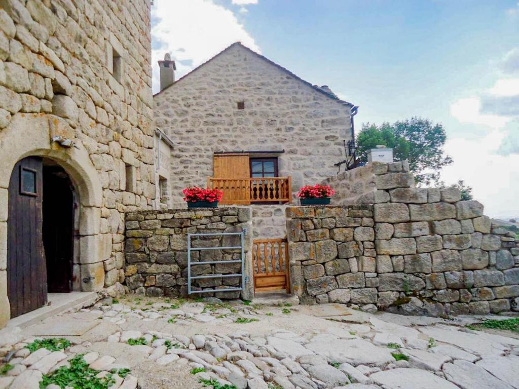 une maison en pierre avec un portail et un mur en pierre dans l'établissement Gites de france 2 pers aux laubies, à Saint-Étienne-du-Valdonnez