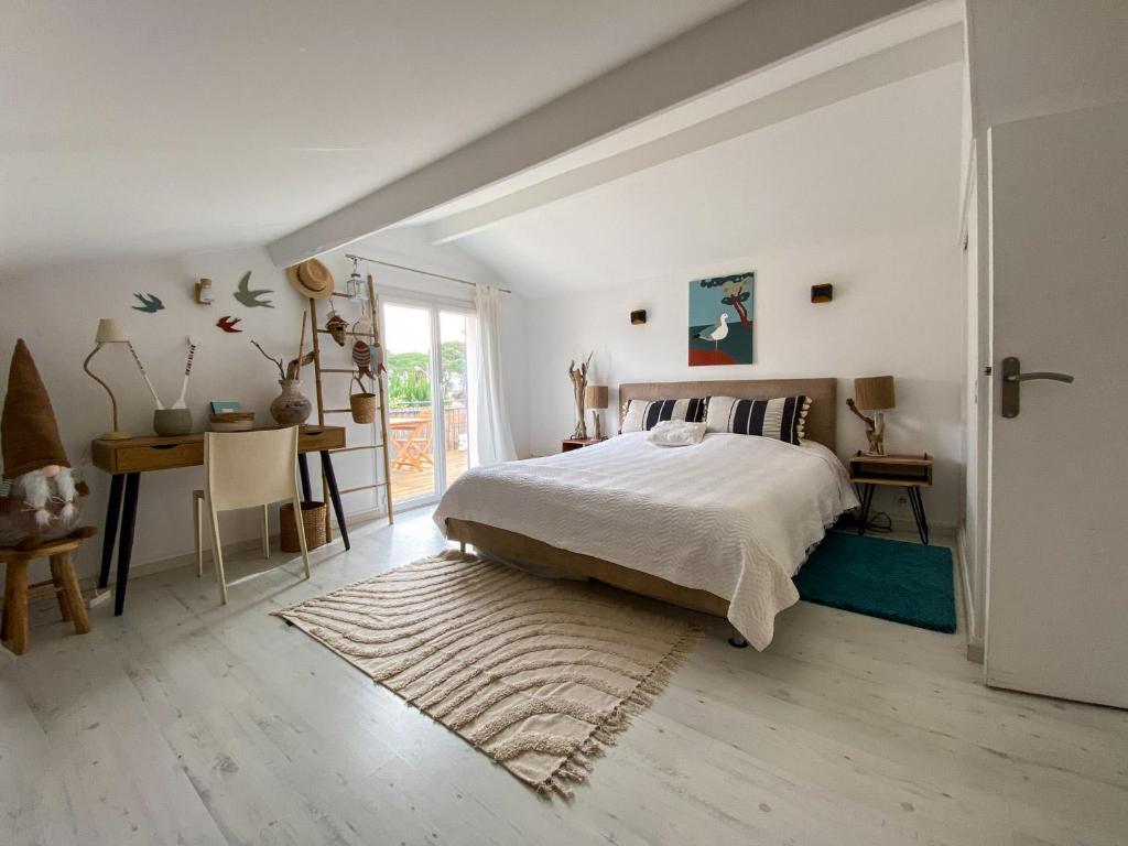 une chambre blanche avec un lit et un bureau dans l'établissement T2 Ayguade HYERES 83, à Hyères